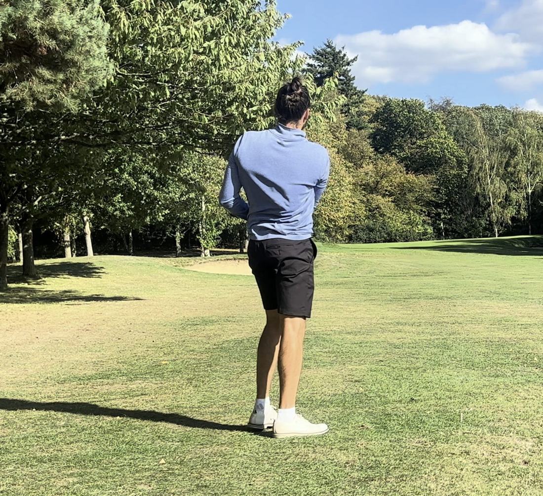 Dan on the fairway, with a red shot tracer arcing towards the green